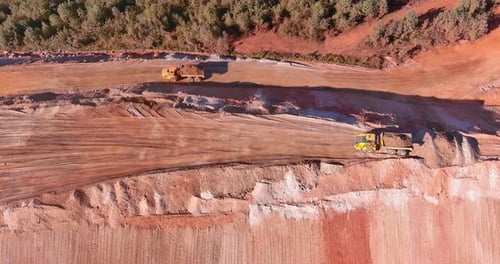 The Earth is Moved to One Place on a Construction Site By Heavy Industrial Earth Moving Vehicles