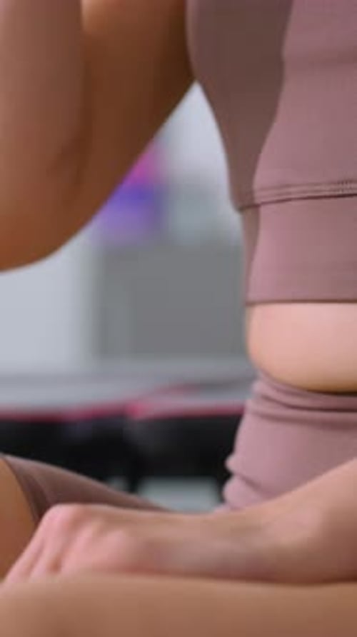 Woman in Gym Outfit with Smartwatch Holding Cup in Relaxed PostWorkout Moment