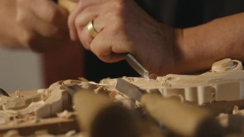 Woodworker Handcrafting Artistry with Chisels in Studio