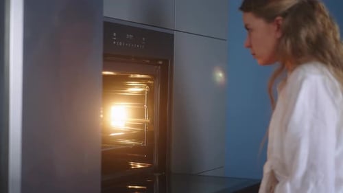 Caucasian Woman Opens the Door of Heated Oven and Puts Inside Pot for Baking Then Closes the Oven