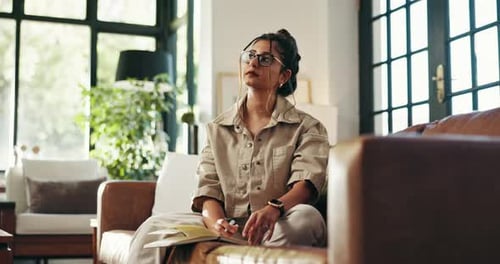 Young Woman Writing in Notebook on Couch at Home