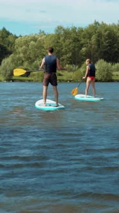 Man and Woman Paddleboarding on a Lake