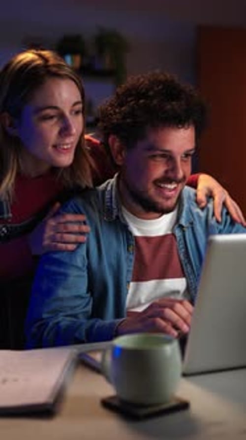 Vertical View of Young Couple at Home Searching New Apartment on Internet Using a Laptop Computer at