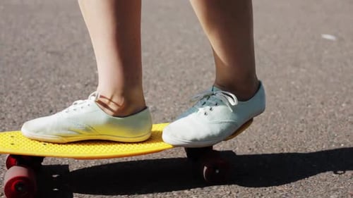 Teen Girl Skateboarding on Road