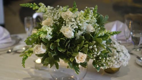 Wedding decoration, centerpiece with Gypsophila paniculata flowers, white roses and green foliage.