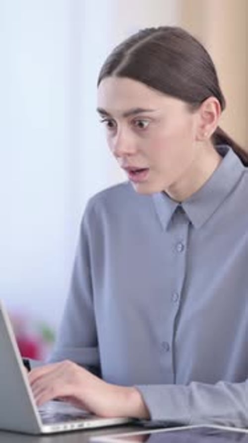 Young Woman Reacts to Success on Laptop