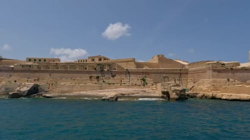 Sailing past the fortress on the coast of Valetta on the island of Malta.