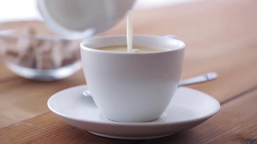 Breakfast, Objects and Drinks Concept - Cream or Milk Pouring From Jug