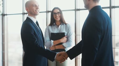 Businessmen Shake Hands in Modern Office