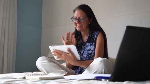 Woman Video Chatting with Tablet on Bed