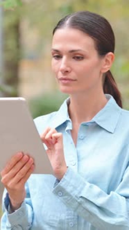 Woman Using Tablet Device in Natural Outdoor Setting