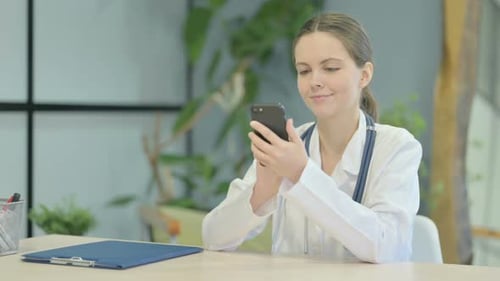 Female Doctor Browsing Smartphone in Clinic