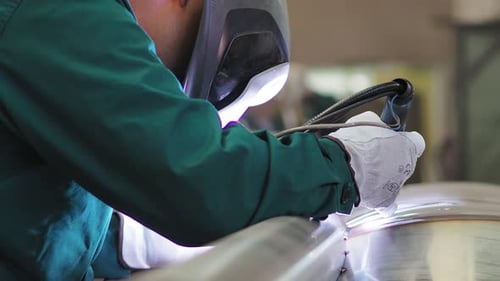 Welder, using VIG, TIG, MIG MAG method to welding stainless steel parts, close up. The welder uses a