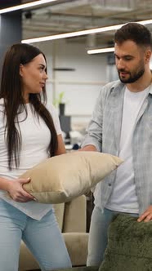 Young Couple Choosing Decorative Pillows in a Furniture Store