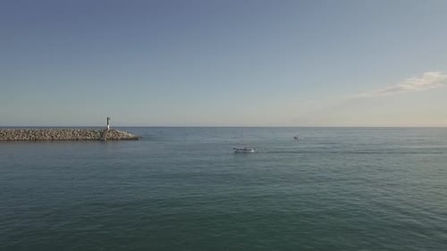 Scenic sunny holiday harbour small boat yacht cruising across clear blue ocean seascape