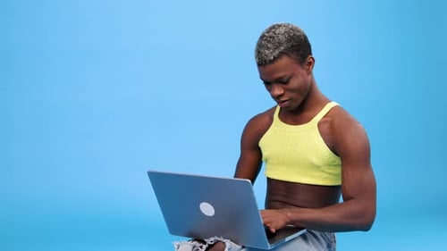 Androgynous Black Person Using a Laptop Computer