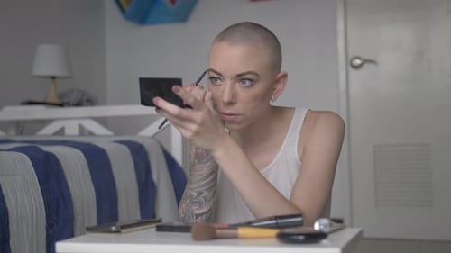 Woman Applies Makeup with Brush in Home Interior