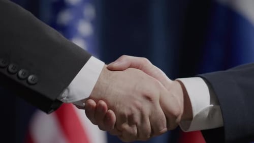 Handshake Between Two Businessmen with Flags