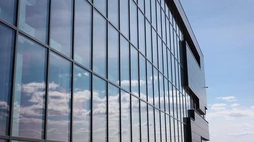 Clouds and Sky are Reflected in the Glass Windows of the Facade of an Office Building Stylish and