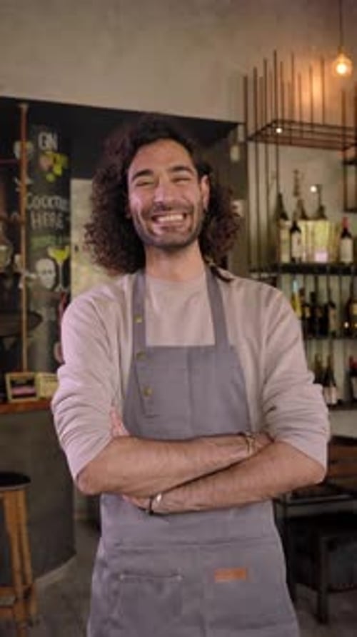 Cheerful Young Man Crossing Arms and Looking to Camera Standing at His New Restaurant