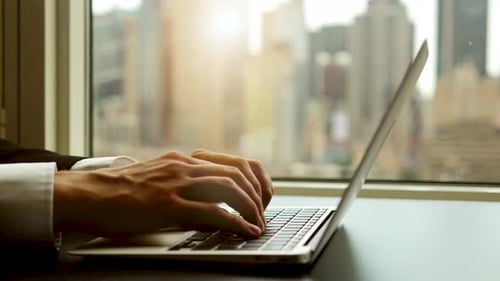 Hands Typing on Laptop in Modern Office