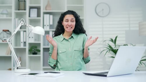 pretty young woman office worker employee showing oops gesture while sitting at workplace Confused p