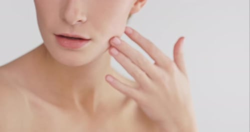 4k video footage of a beautiful young woman caressing her skin against a studio background