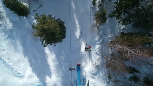 Vista aérea desde arriba de un telesilla móvil entre los árboles de la estación de esquí