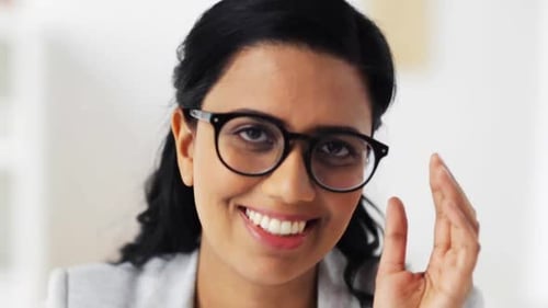 Smiling woman wearing glasses looks at the camera