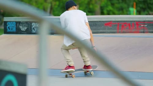 Young Adult Skateboarder Performing an Ollie in Skate Park