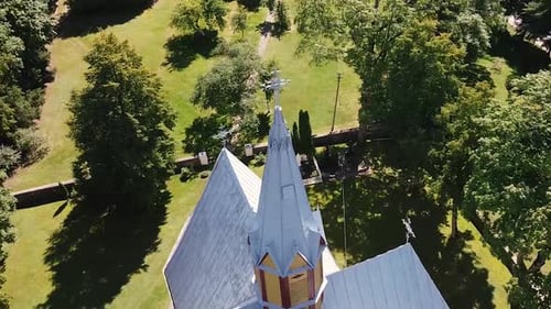 Arial Drone shot of church towers cross at the top. Orbit shot or a church. 2022 Lithuania.