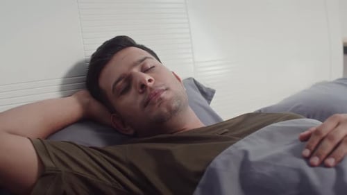 Man Sleeping Peacefully in Bed at Home