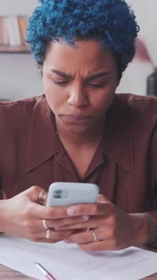 Young Joy African American Woman Entrepreneur Uses Phone Sits in Office at Table
