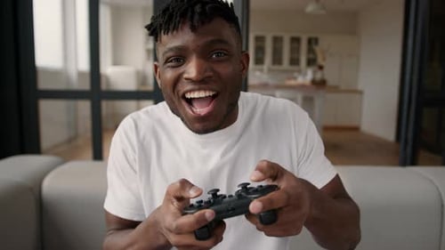 Excited Man Playing Video Game at Home