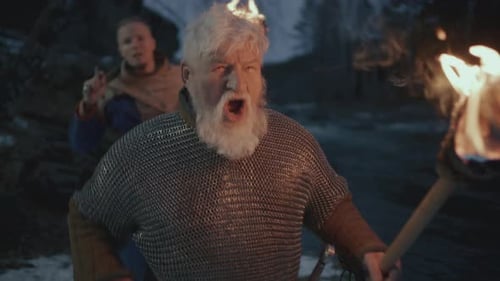 Senior Man with Torch and Axe at Night