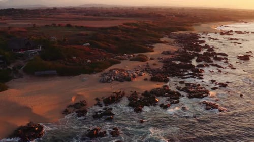 Sun rises as waves from the Pacific Ocean crash in front of beautiful luxury rental villas in Oaxaca