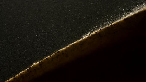 Small sand particles falling down the hill in abstract macro slow motion