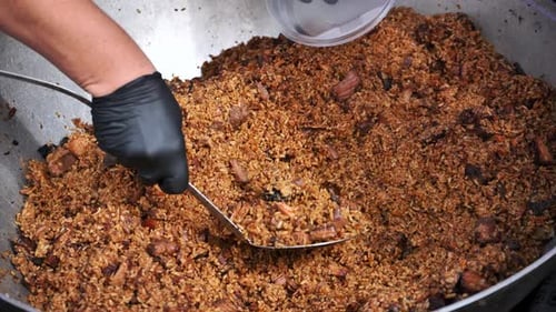 Chef Serving Traditional Indian Biryani Rice with Meat in Large Pot