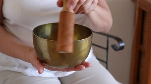 Woman plays singing bowl for meditation and wellness