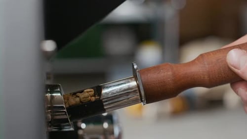 Hand rotates coffee bean roaster's cylinder