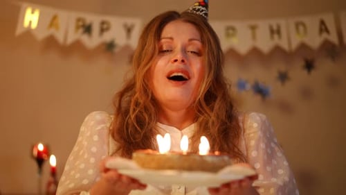 Woman Blowing Out Birthday Candles with Joy