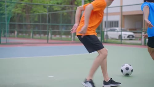Asian two sportsman practicing football playing in the outdoors stadium.