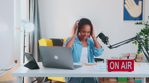 Woman Putting On Headphones, Speaking into Microphone