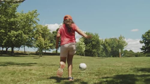 Petite fille jouant avec un ballon dans le parc par une journée d'été ensoleillée