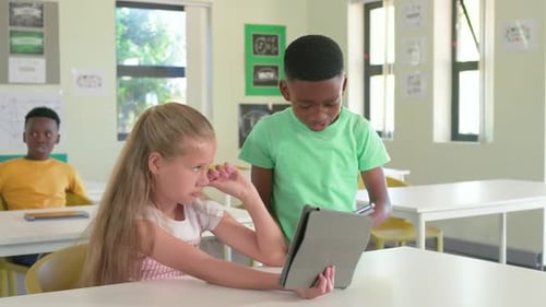 Diverse students comparing tablets with boy approaching, girl angling gray case, rear youth tapping
