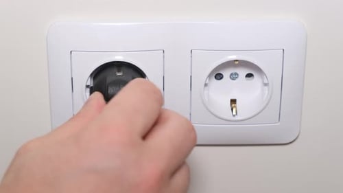 Plan rapproché de la connexion du cordon d'alimentation à une prise électrique