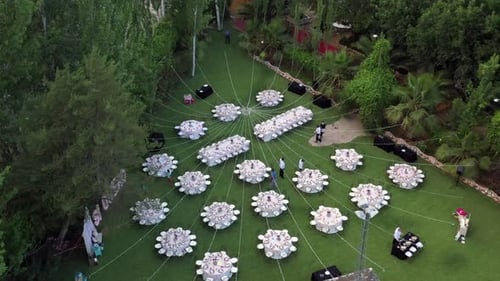 A drone shot of a food court of a wedding ceremony. Event people are supervising the place in day ti