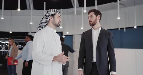Muslim Entrepreneur and Caucasian Manager Meeting in Office Workspace Corridor Negotiating Agrement