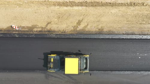 Aerial Shot of Slowly Driving Roller Laying New Asphalt Layer