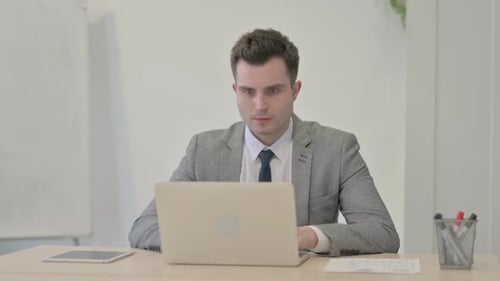 Young Businessman Reacting to Loss While Working in Office